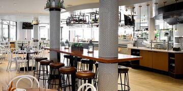 a bar with stools and tables in a restaurant