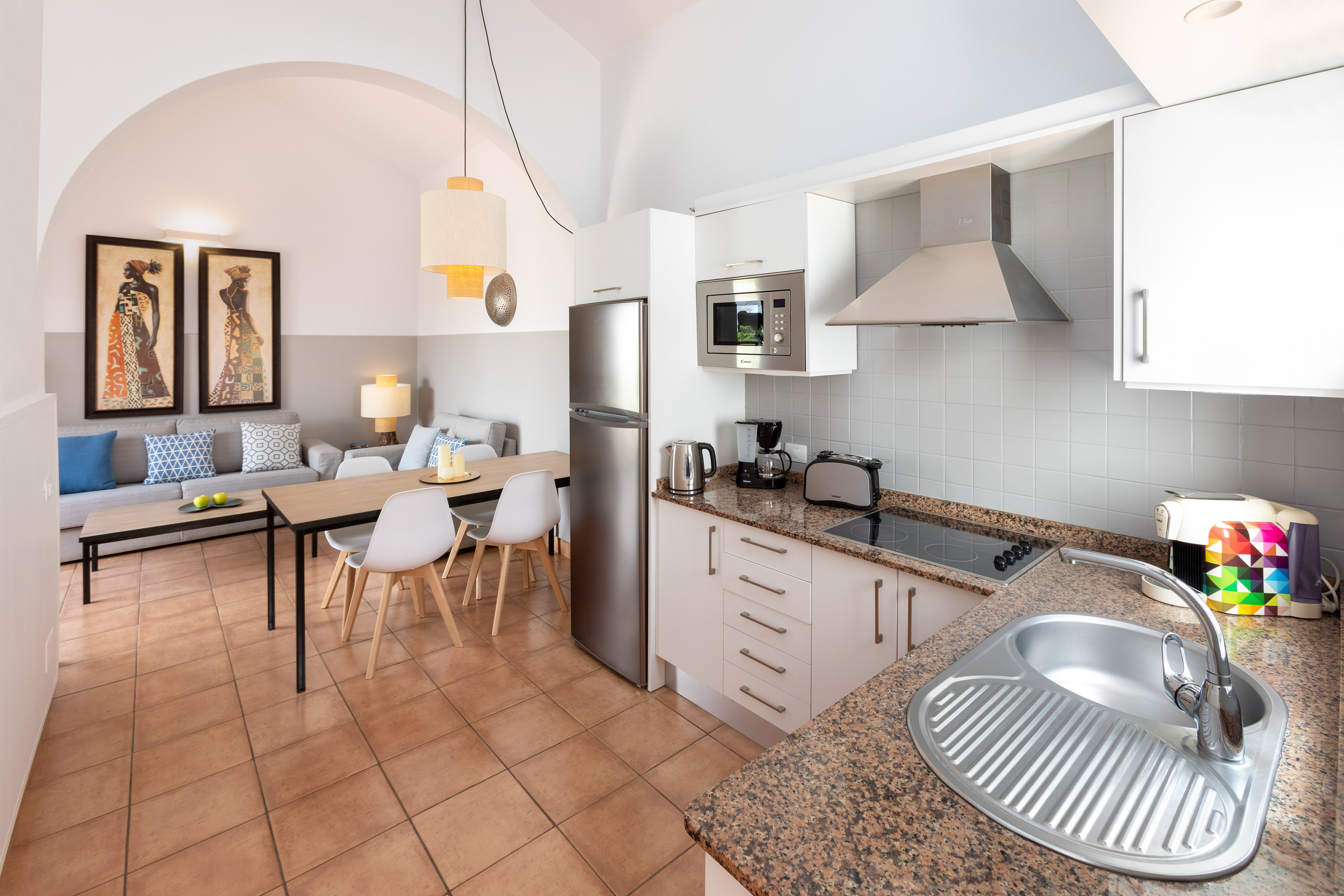 Open-plan apartment kitchen, dining, and living area with modern appliances.