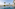 Tropical resort infinity pool with palm trees, ocean view, and luxury daybeds.