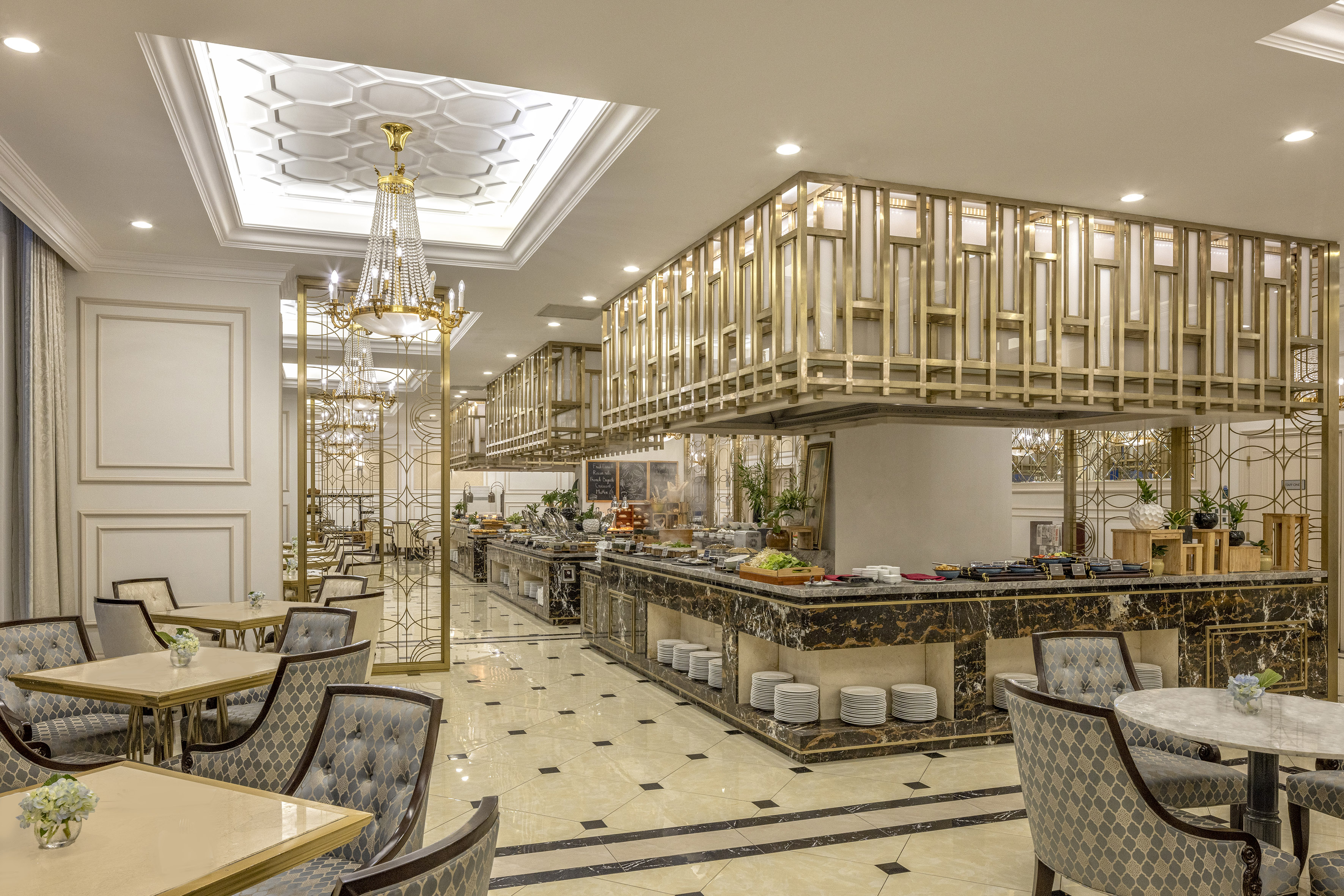 Luxury hotel buffet with marble counters, gold decor, and elegant seating.