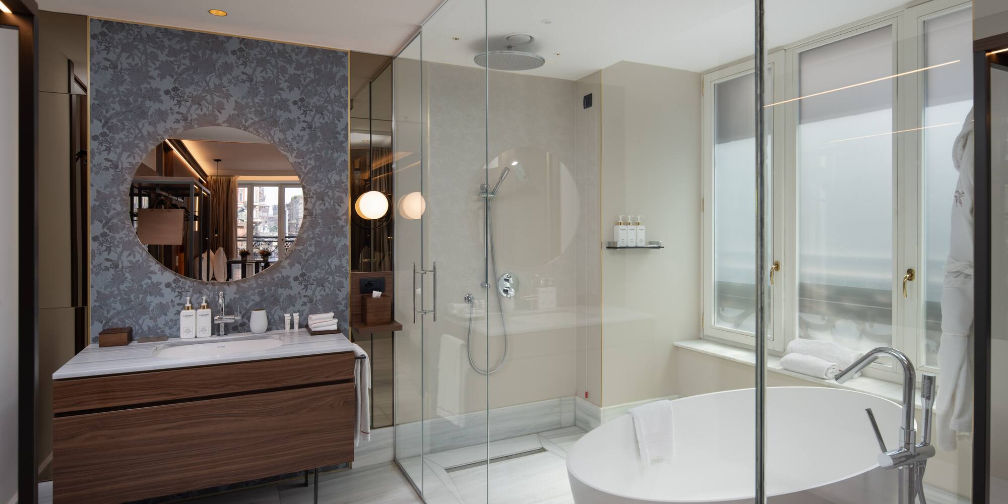 Luxury hotel bathroom with modern design, freestanding tub, glass shower, marble vanity.