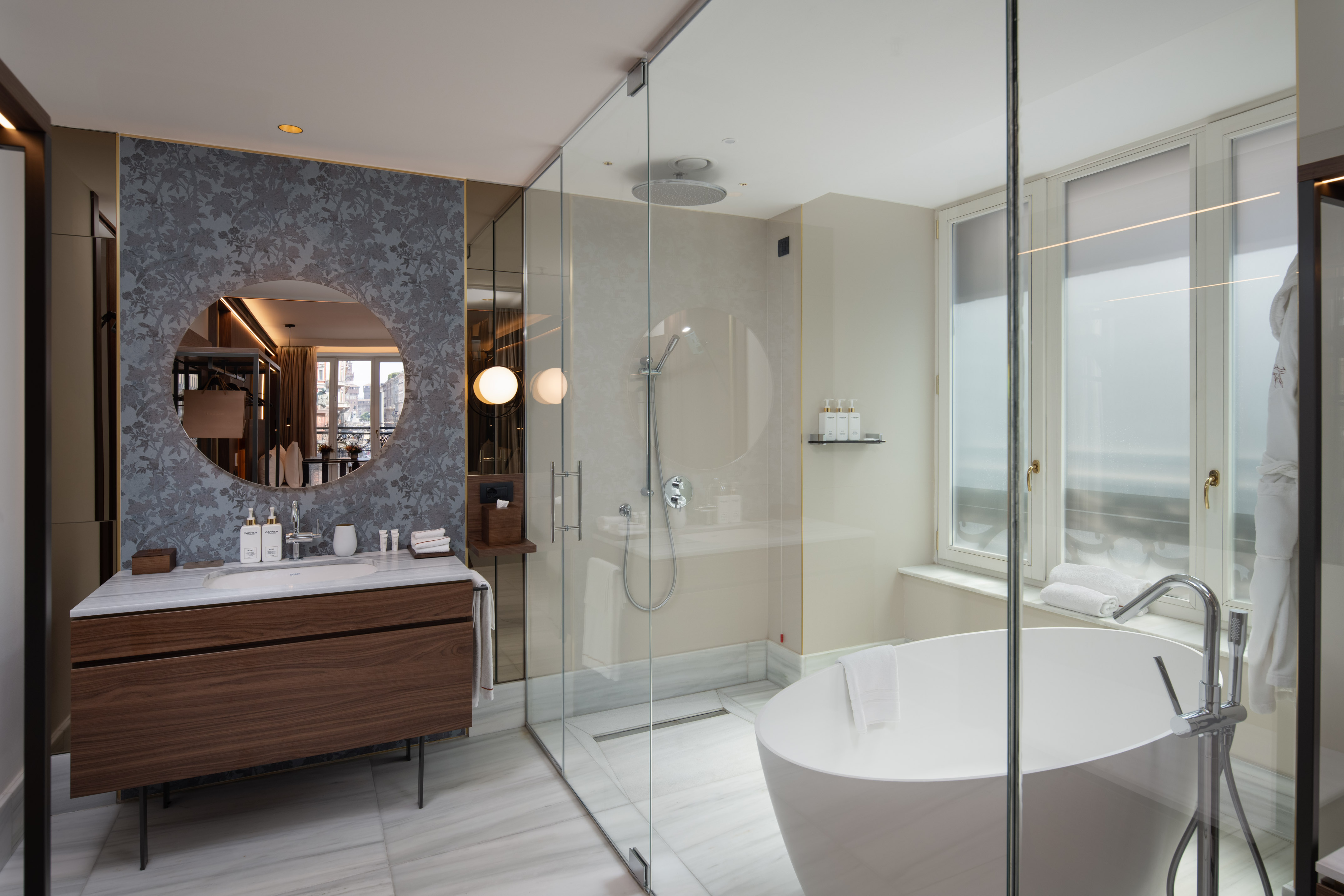 Luxury hotel bathroom with modern design, freestanding tub, glass shower, marble vanity.