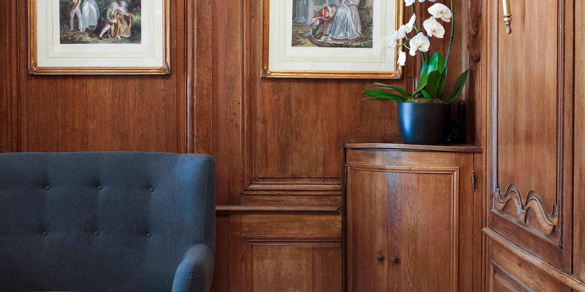 a room with a couch and paintings on the wall