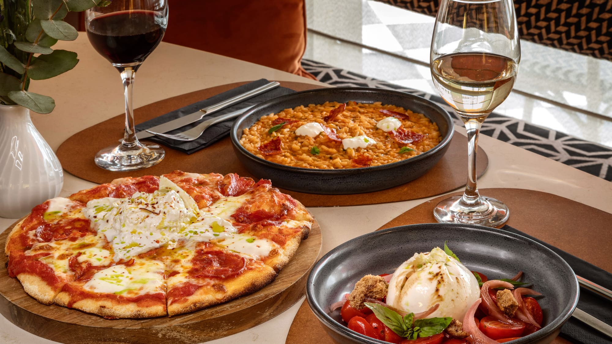 Italian meal: pizza, creamy risotto, burrata salad, red and white wine.