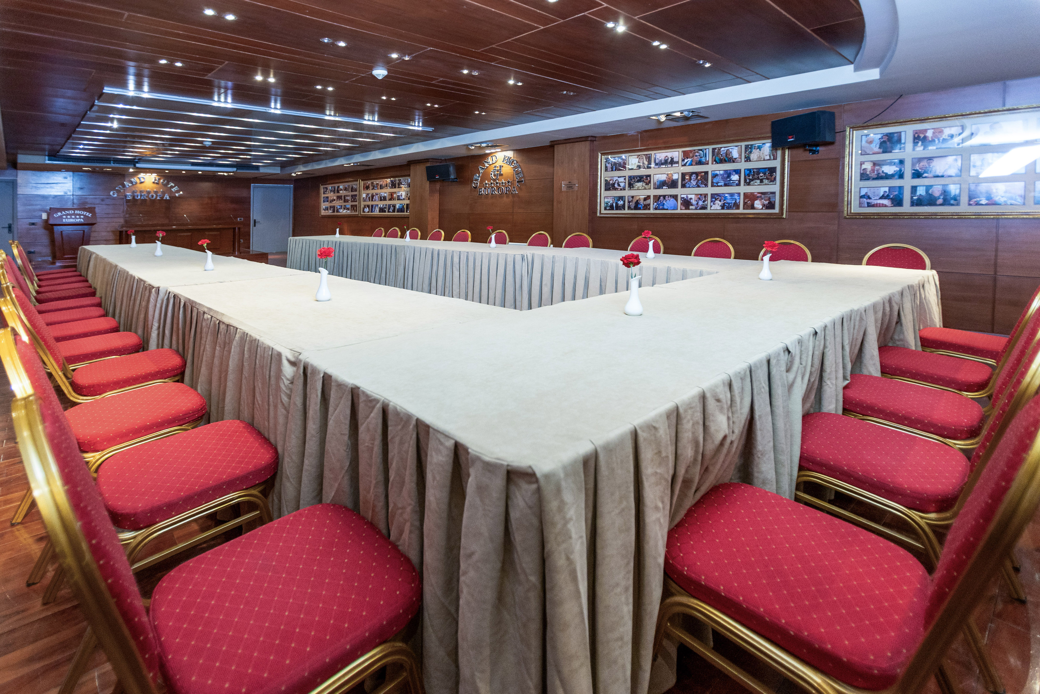 Grand Hotel Europa conference room with U-shaped table, red chairs, wood interior.