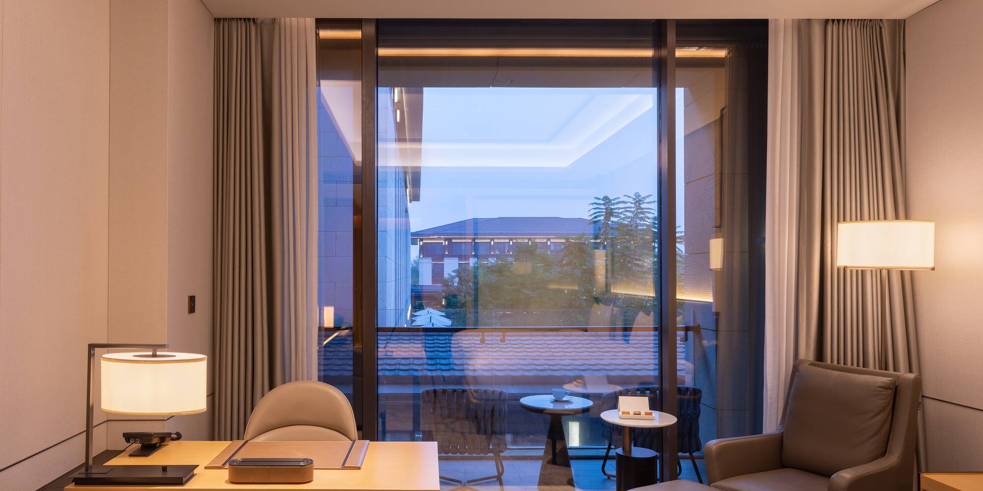 a room with a large window and a bed and a table