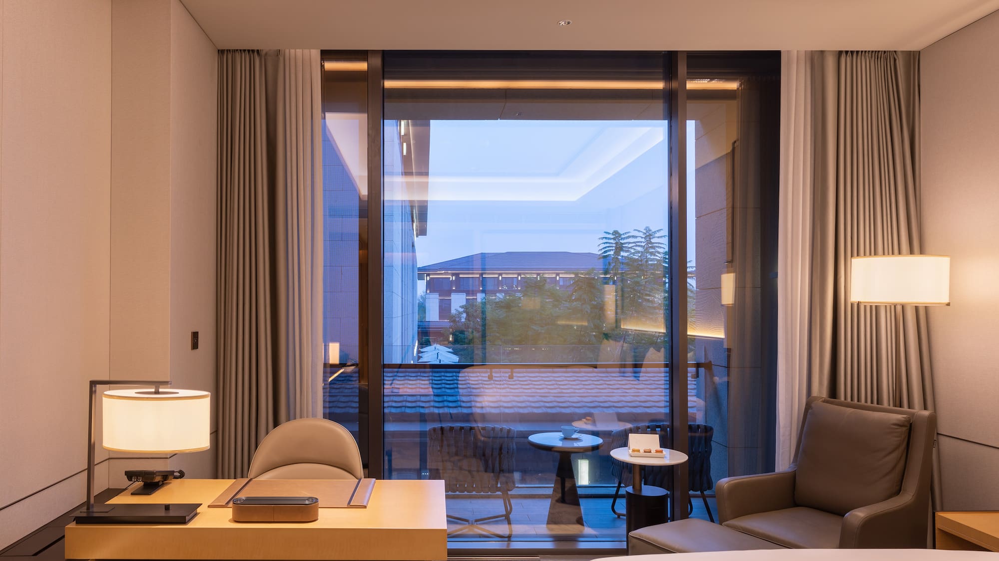 a room with a large window and a bed and a table