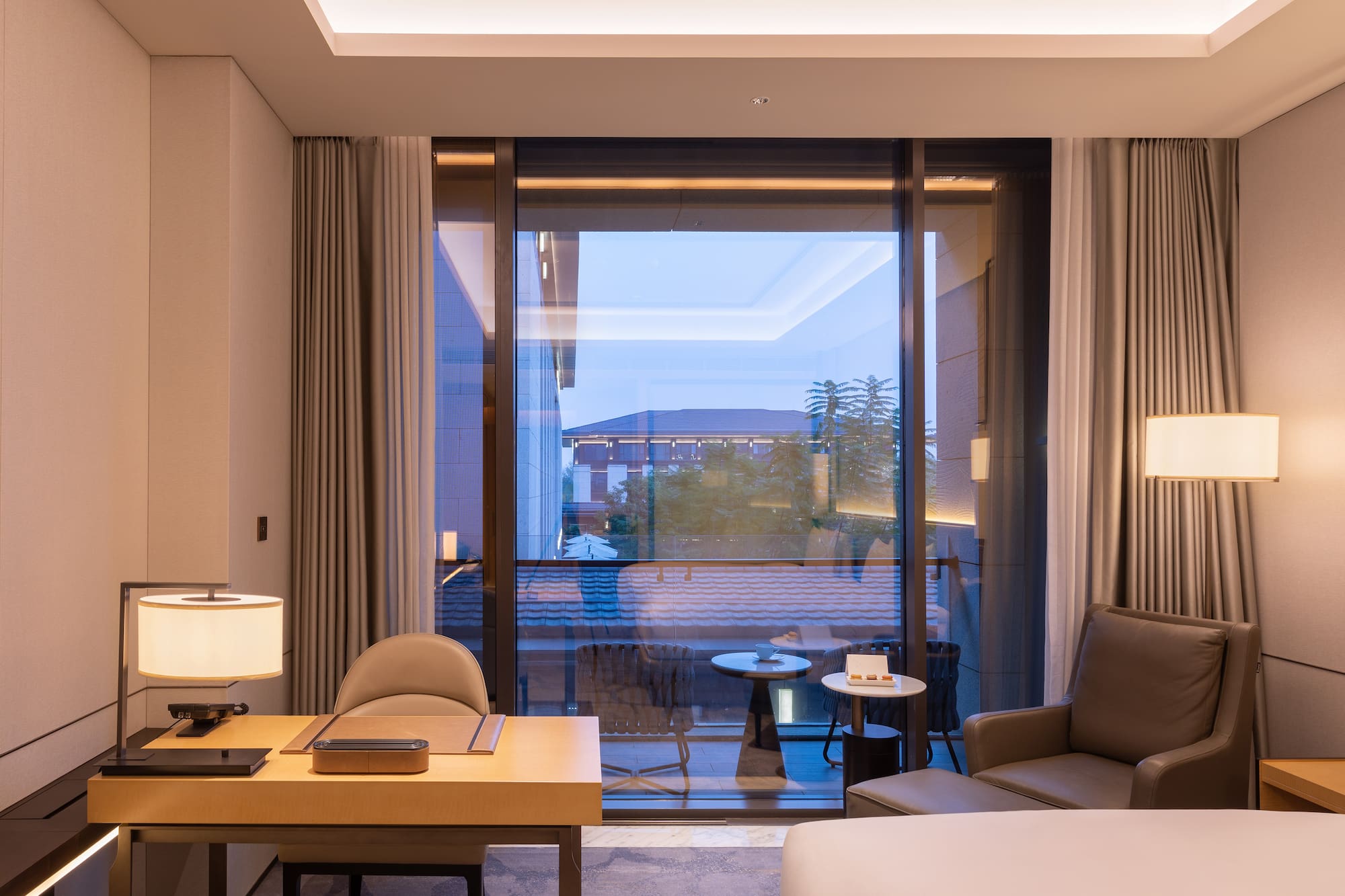 a room with a large window and a bed and a table