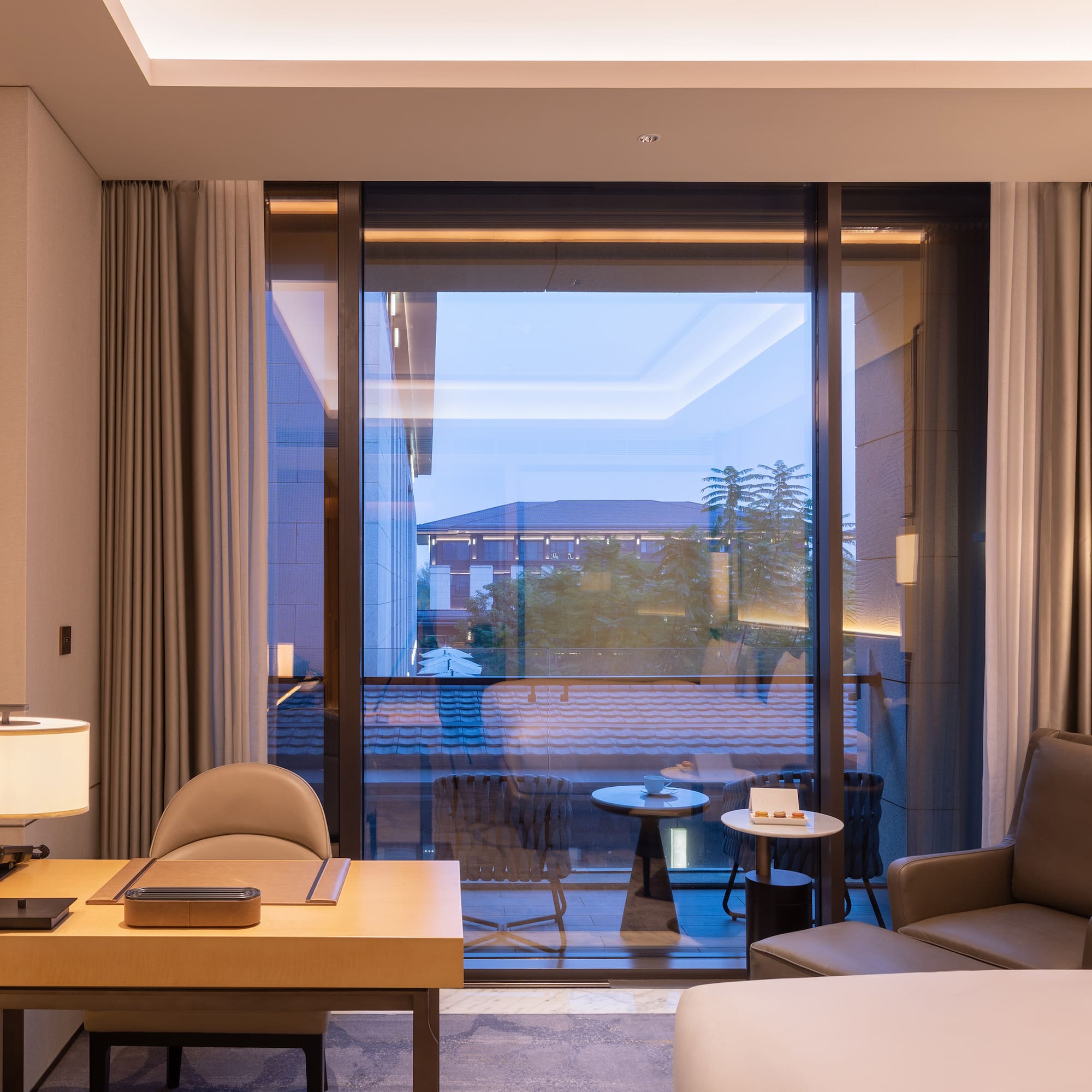 a room with a large window and a bed and a table