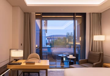 a room with a large window and a bed and a table