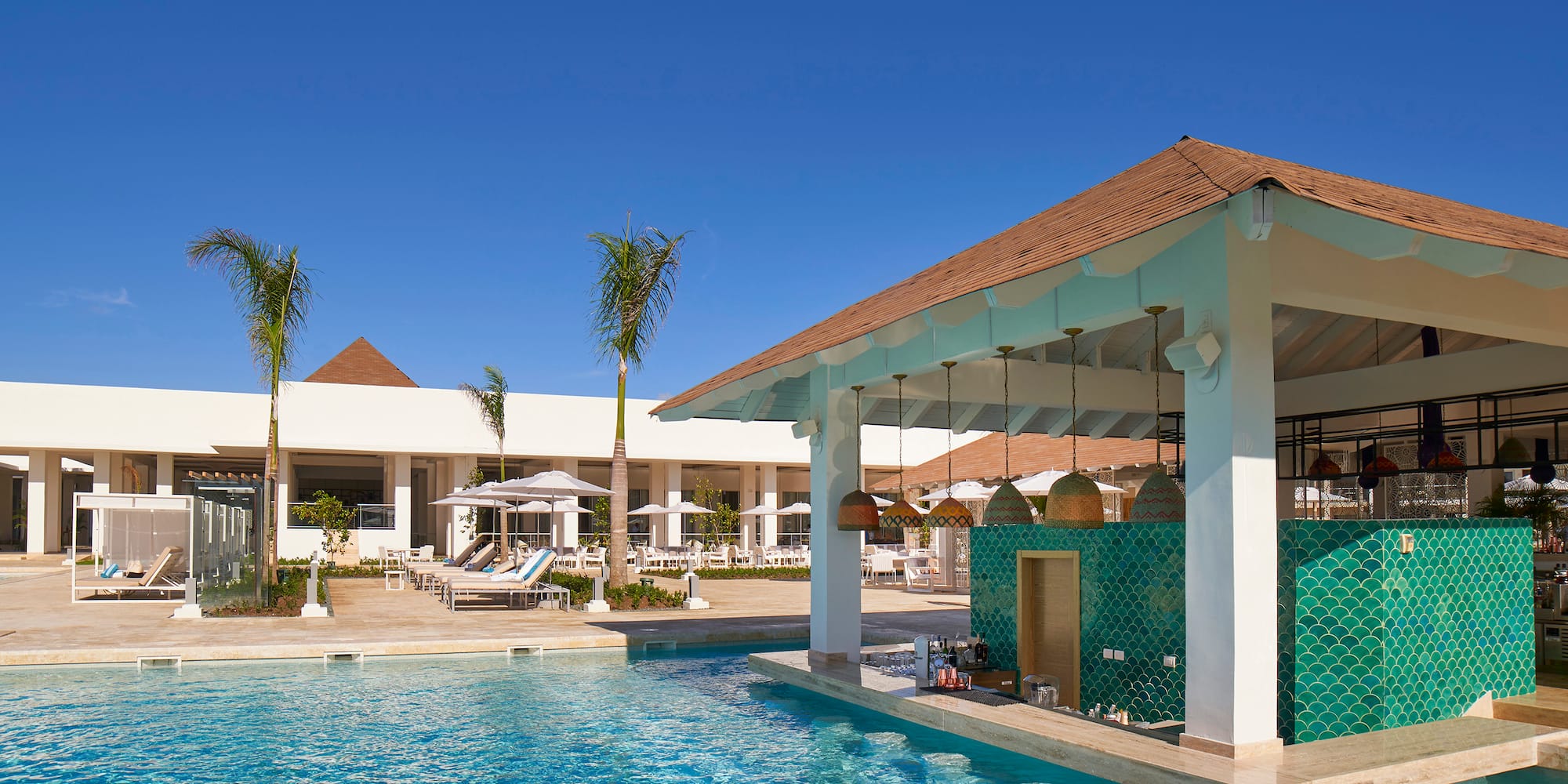 a pool with a bar and chairs in the background