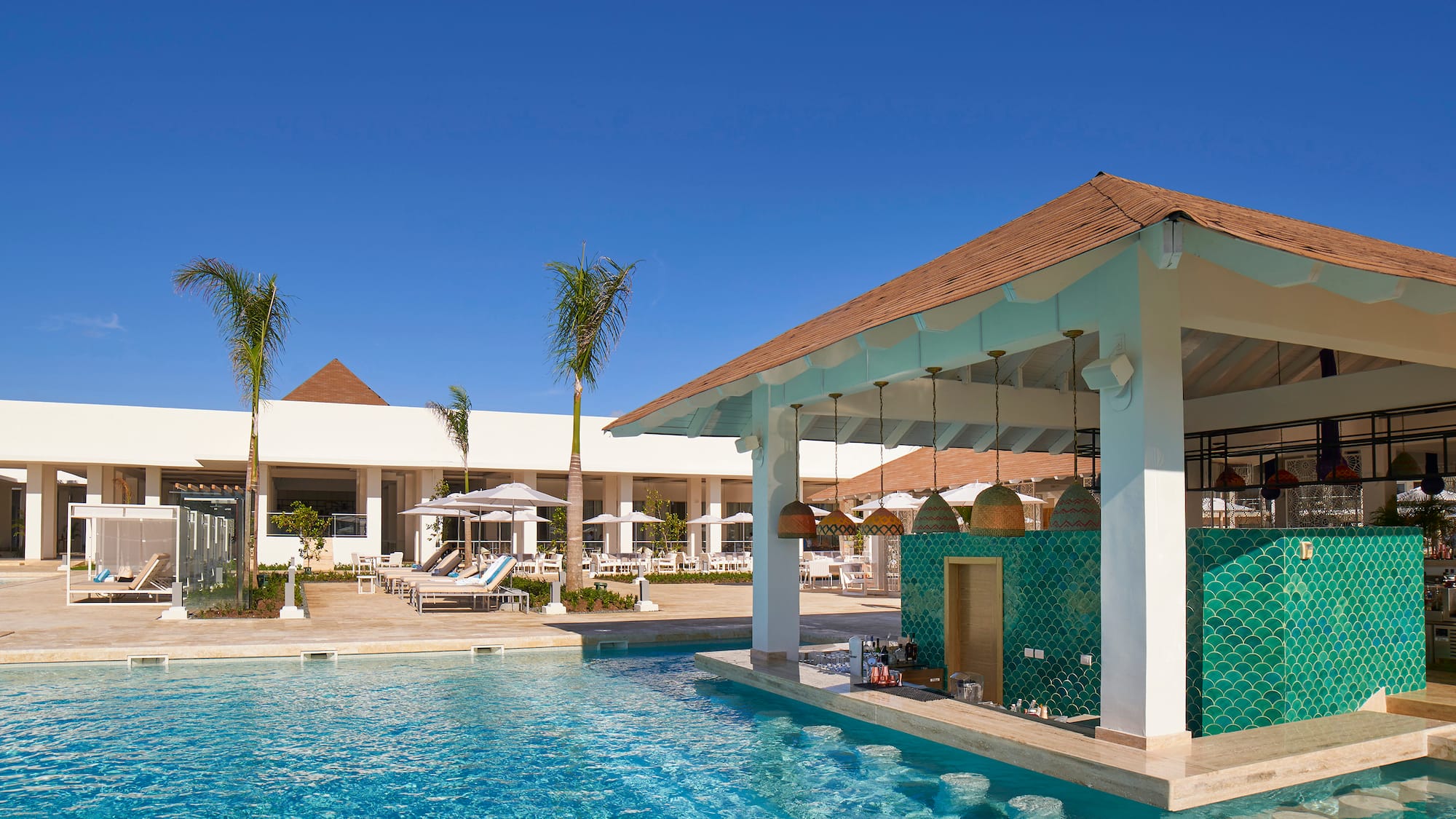 a pool with a bar and chairs in the background