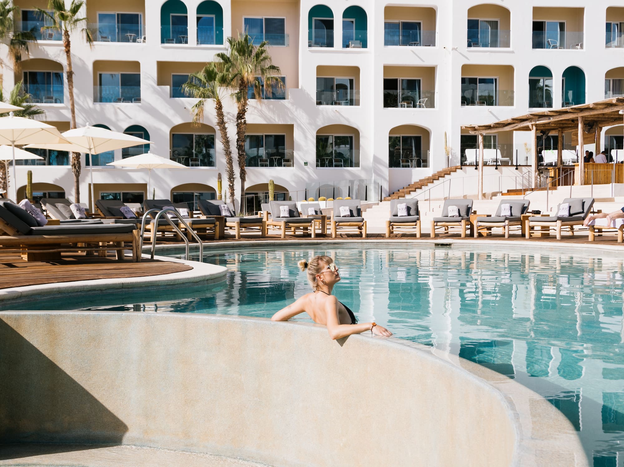 a woman in a pool with a white building behind her