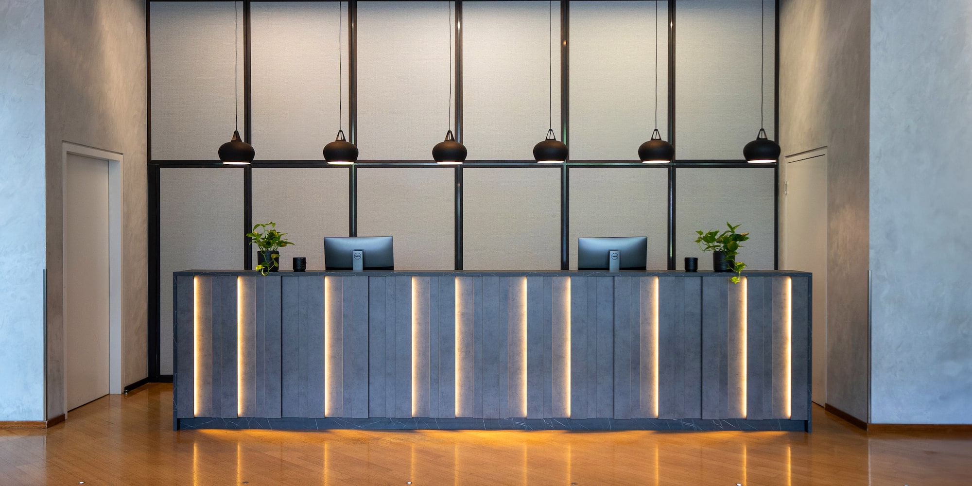 a reception desk with lights from ceiling