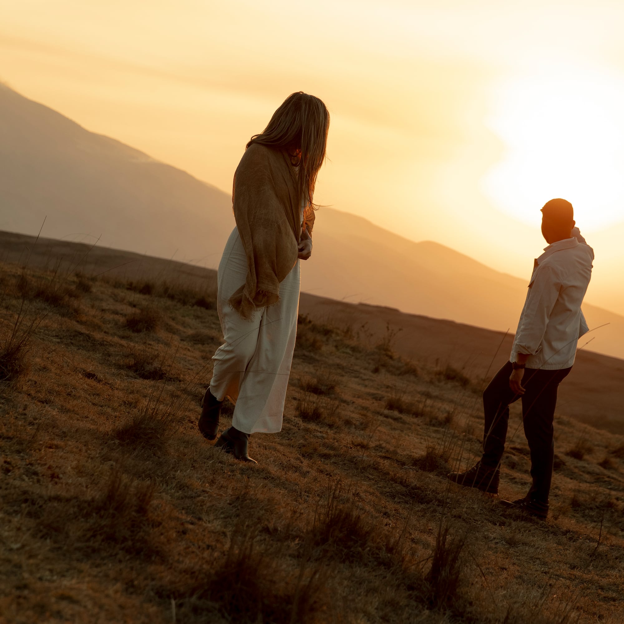 a man and woman walking in a field
