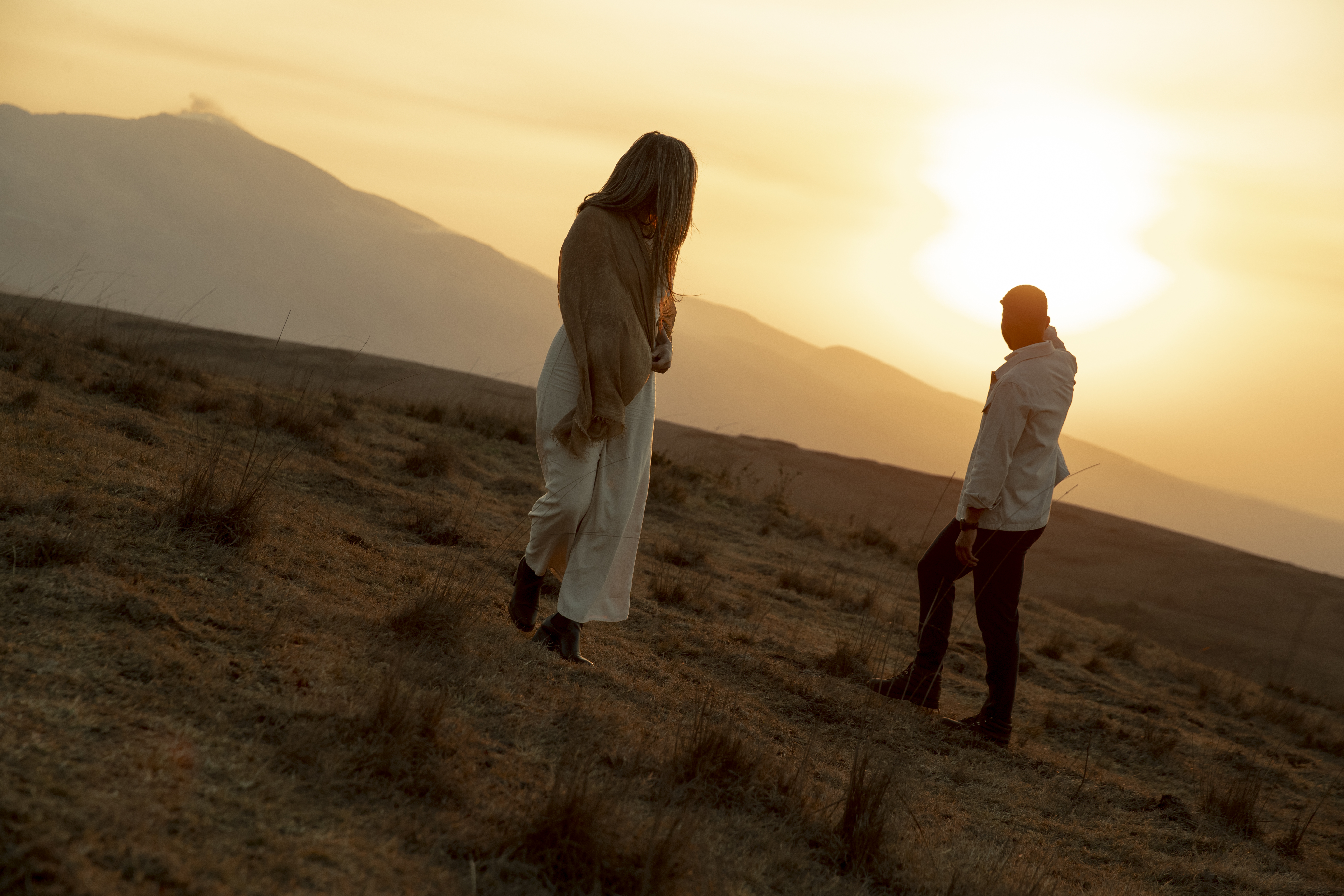 a man and woman walking in a field