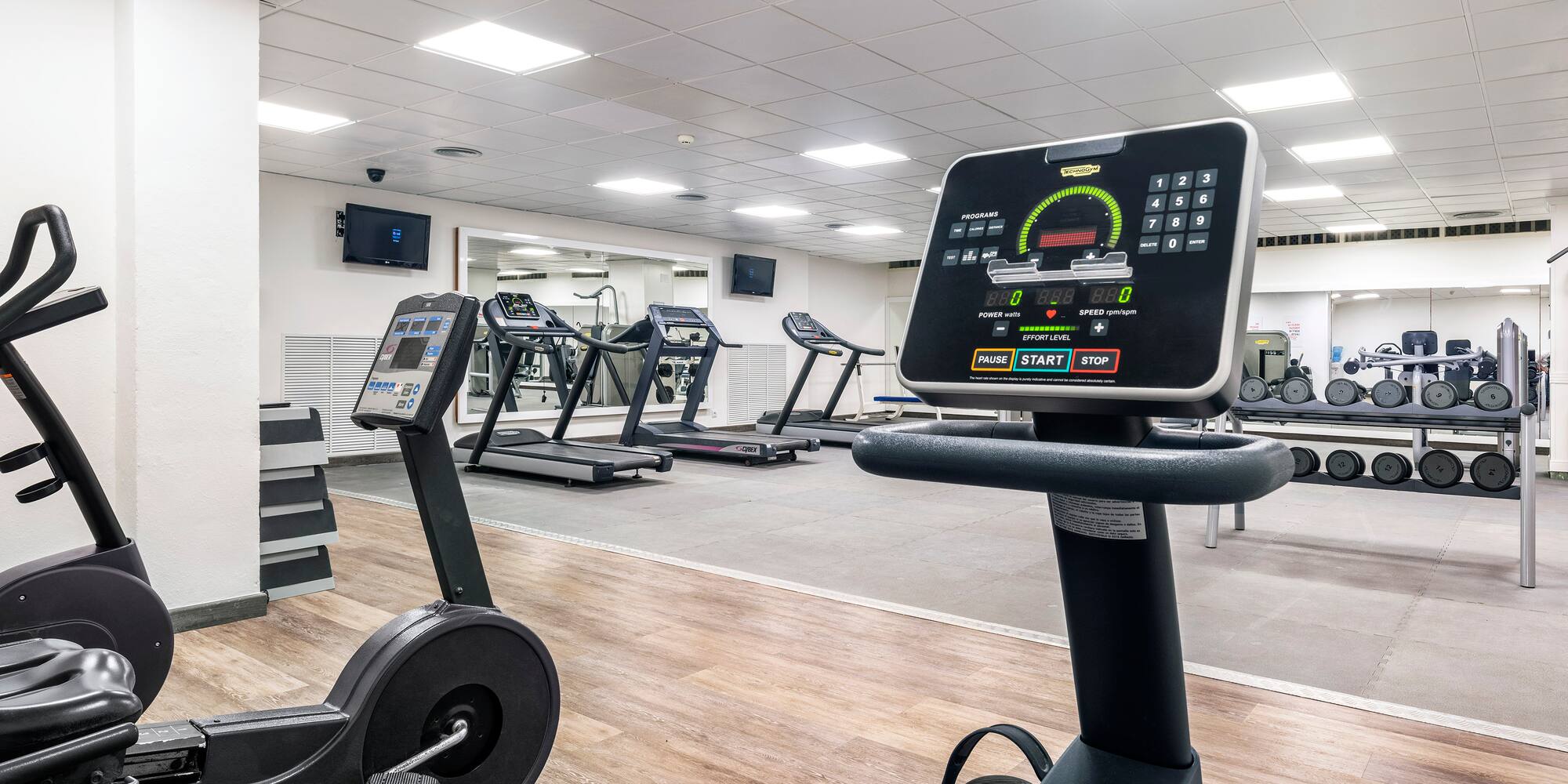 a room with treadmills and a screen