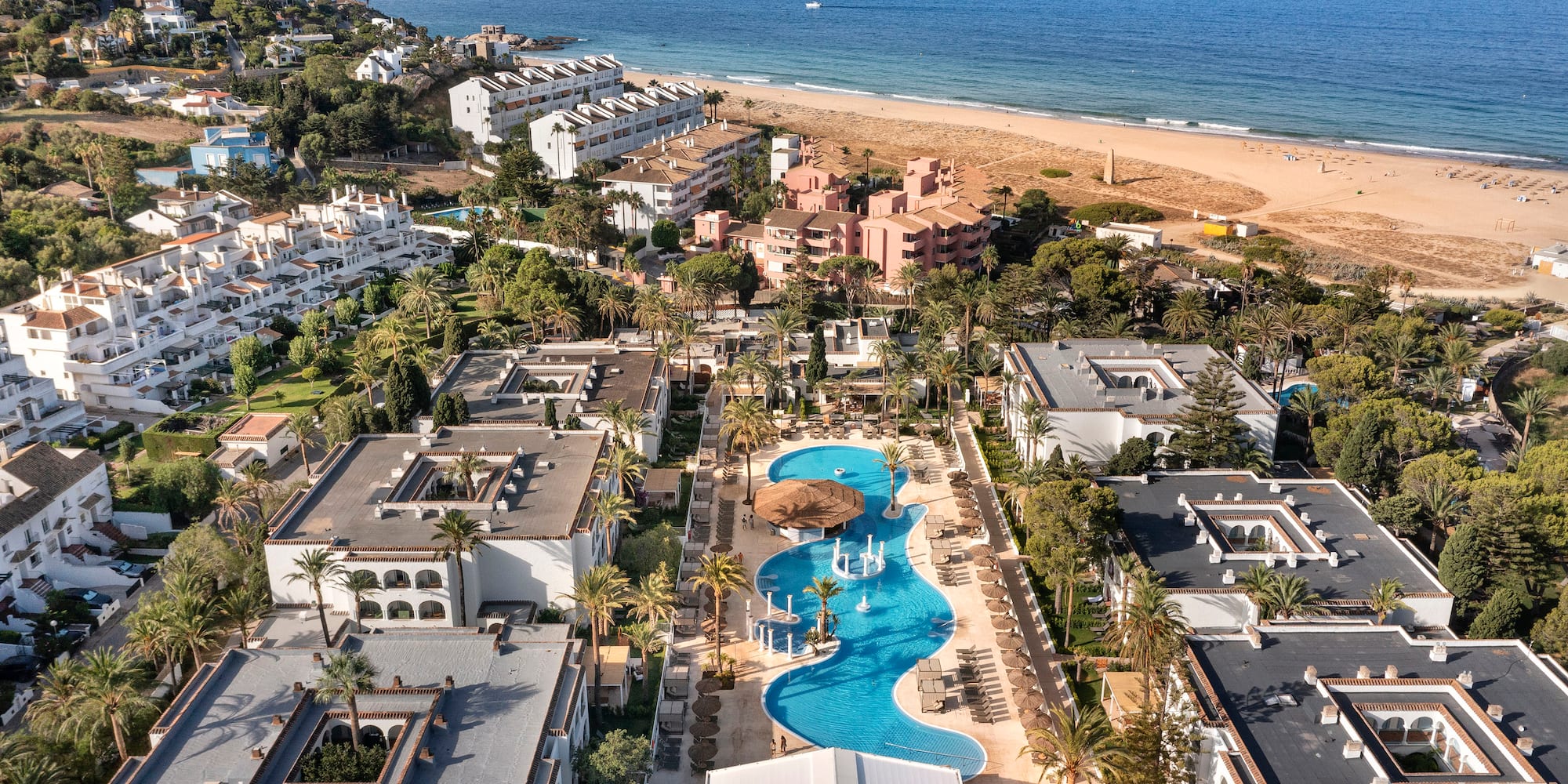 a swimming pool and buildings next to a beach