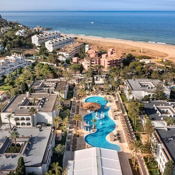 a swimming pool and buildings next to a beach