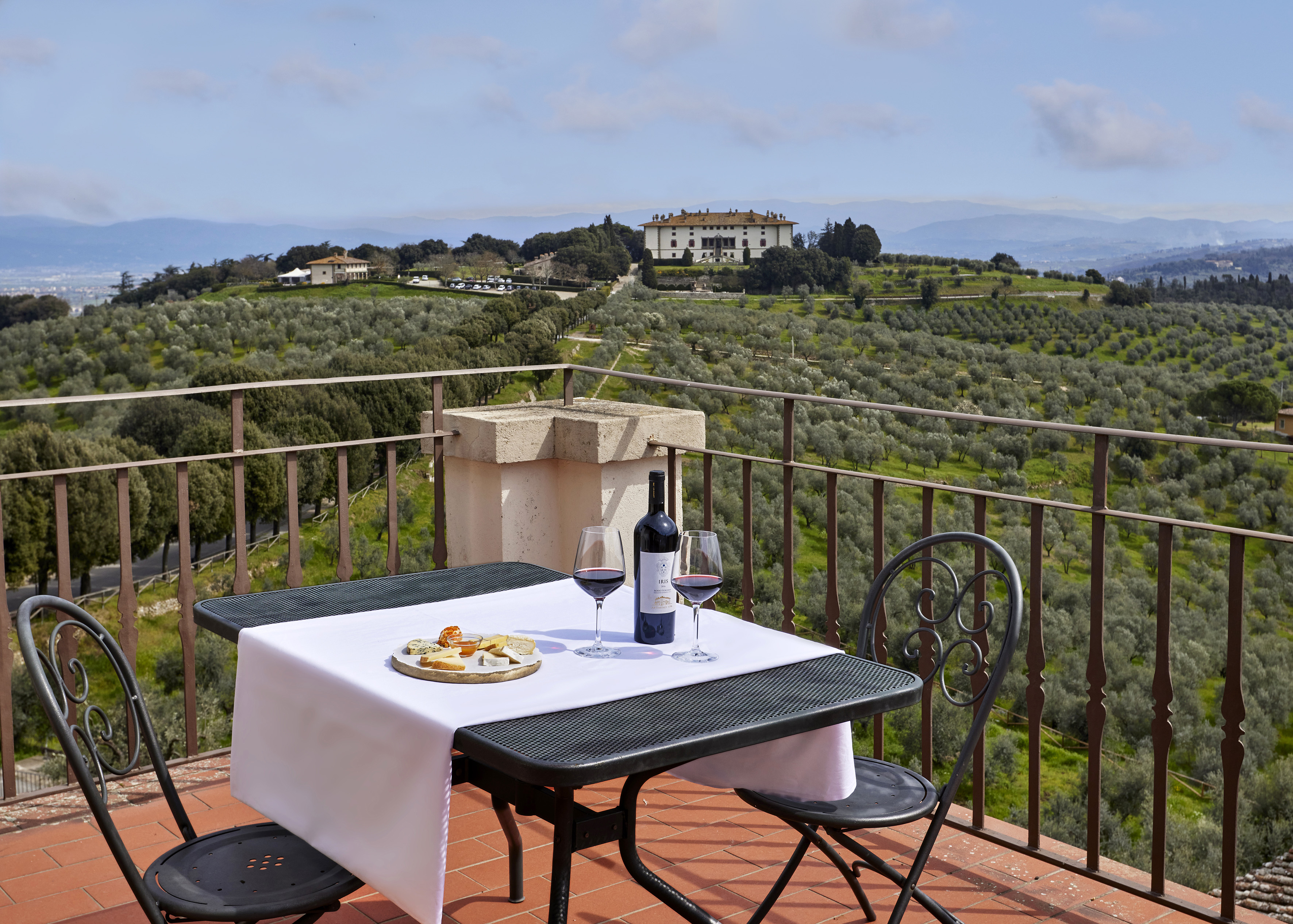 a table with wine and food on it overlooking a vineyard