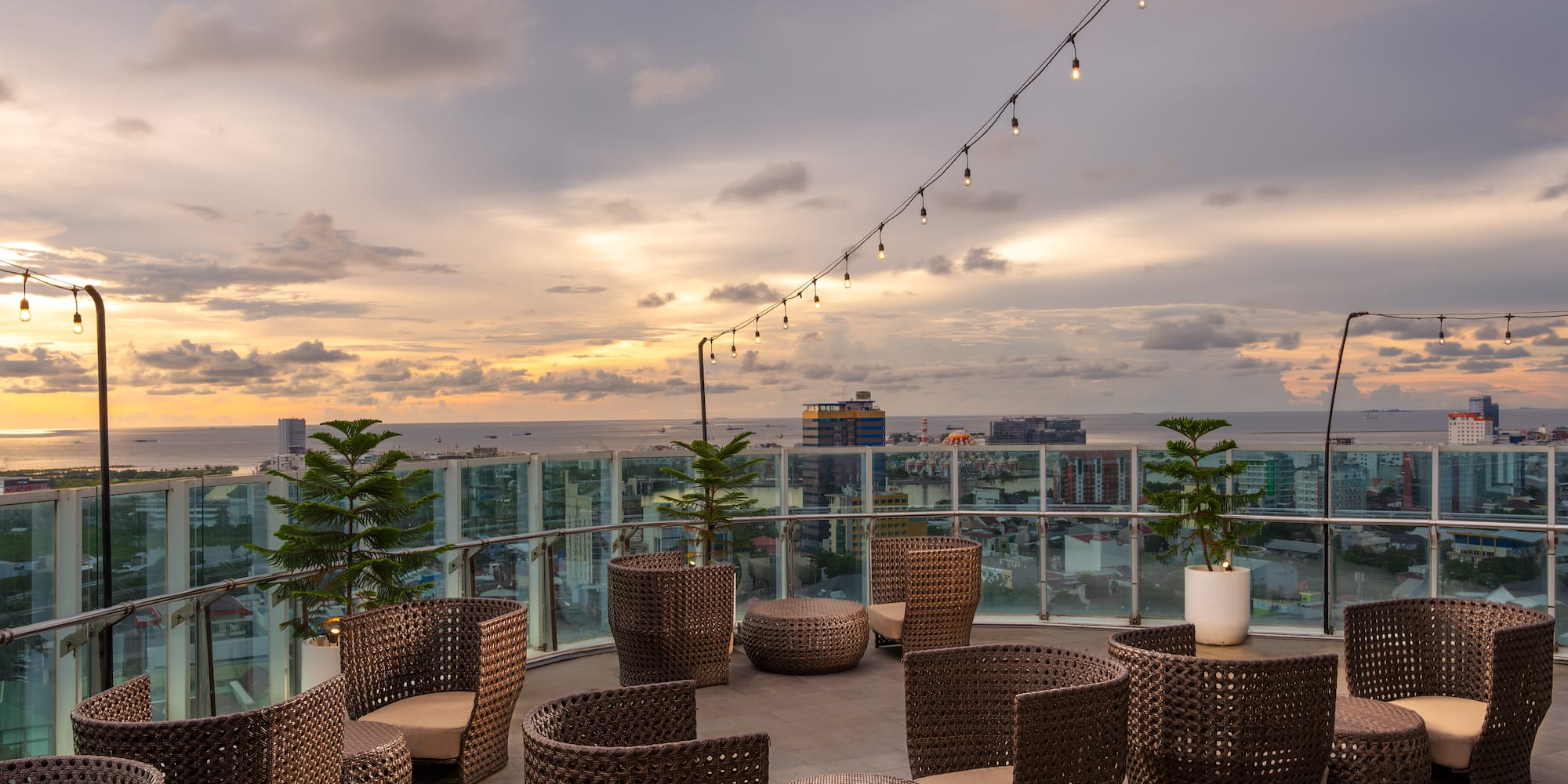 a patio with chairs and a string of lights
