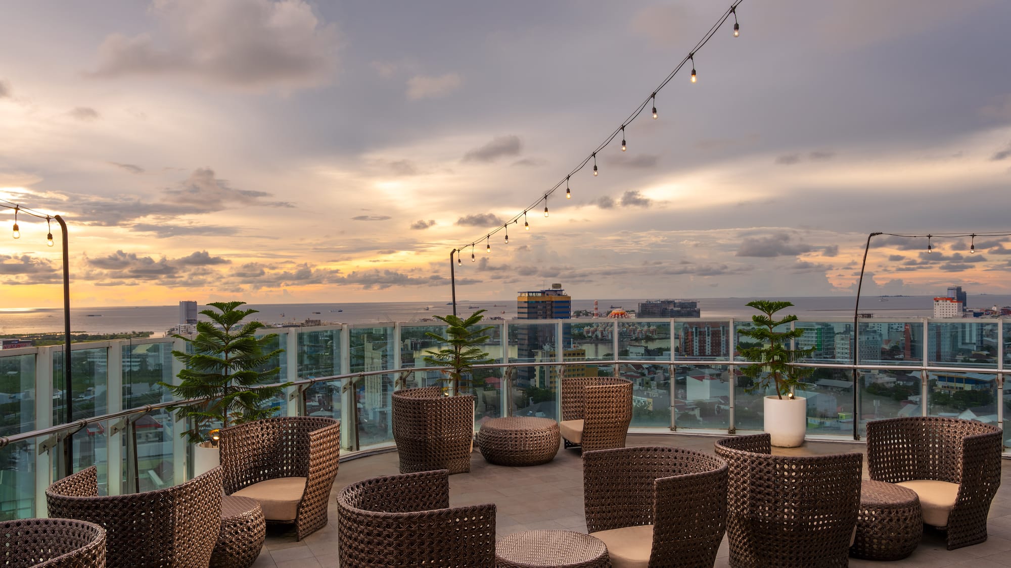 a patio with chairs and a string of lights