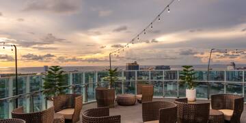 a patio with chairs and a string of lights