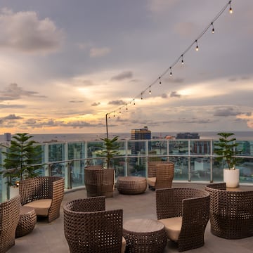 a patio with chairs and a string of lights