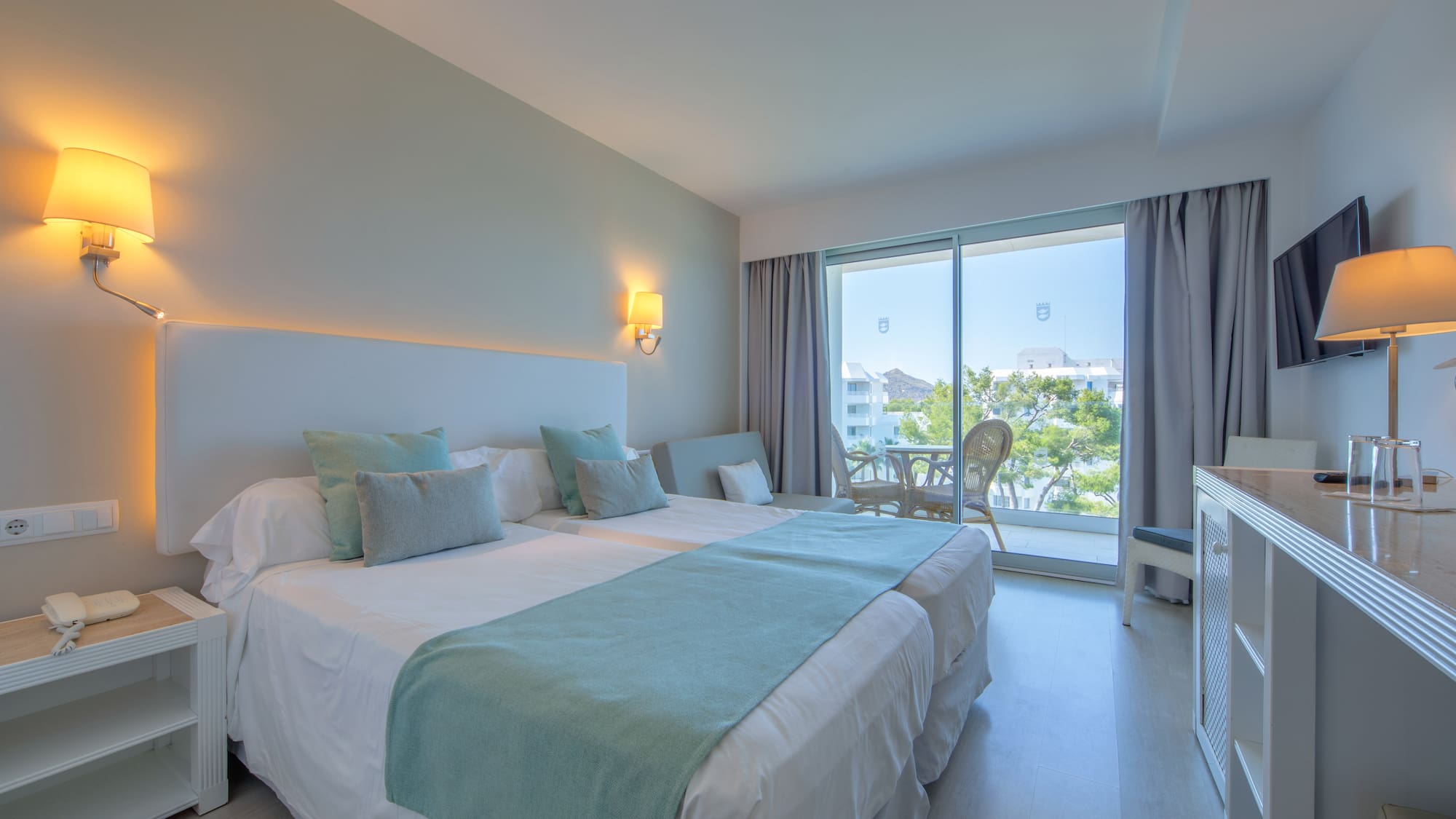 a bedroom with a large bed and a glass door