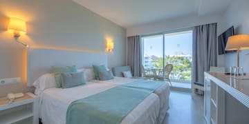 a bedroom with a large bed and a glass door