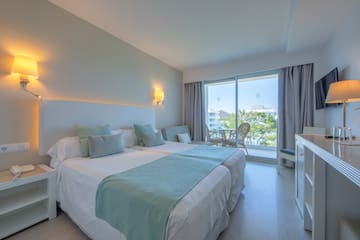 a bedroom with a large bed and a glass door