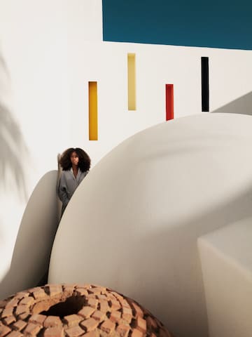 a woman standing in a white room with colorful walls