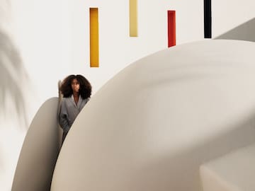 a woman standing in a white room with colorful walls