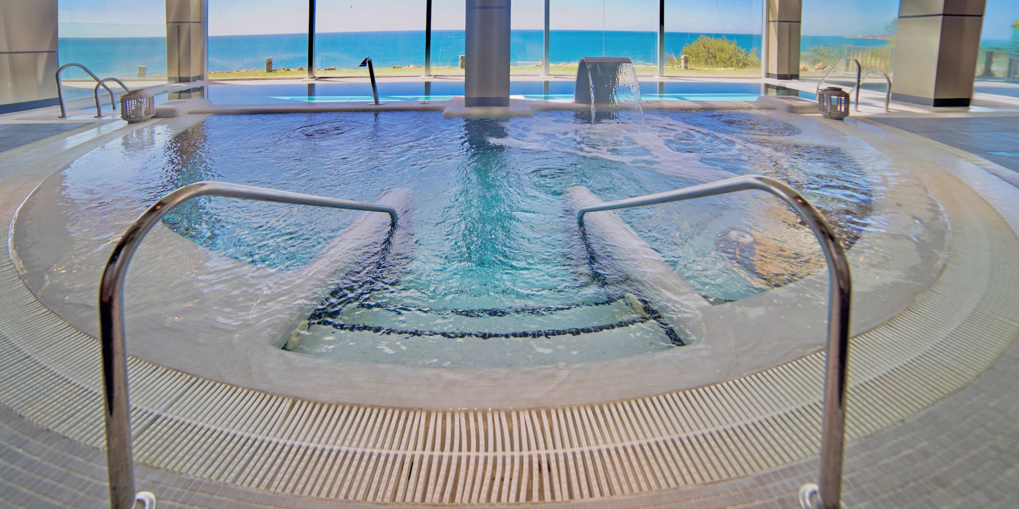 a large indoor pool with stairs and railings