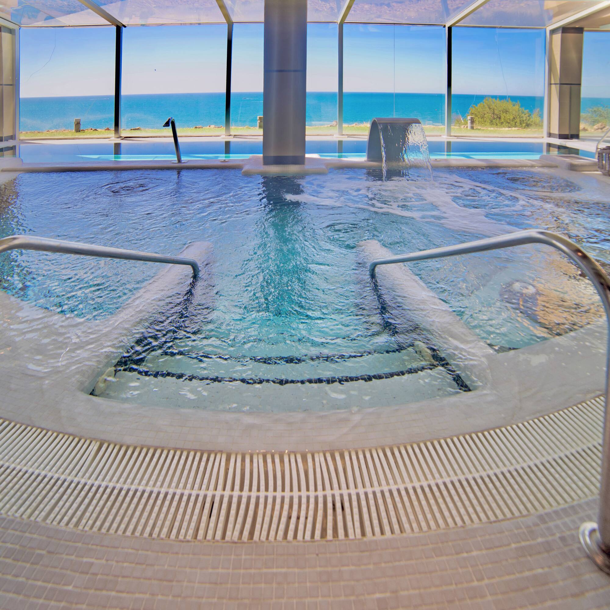 a large indoor pool with stairs and railings