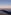 Teide volcano shadow over clouds at sunrise from rocky summit.