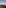 Teide volcano shadow over clouds at sunrise from rocky summit.