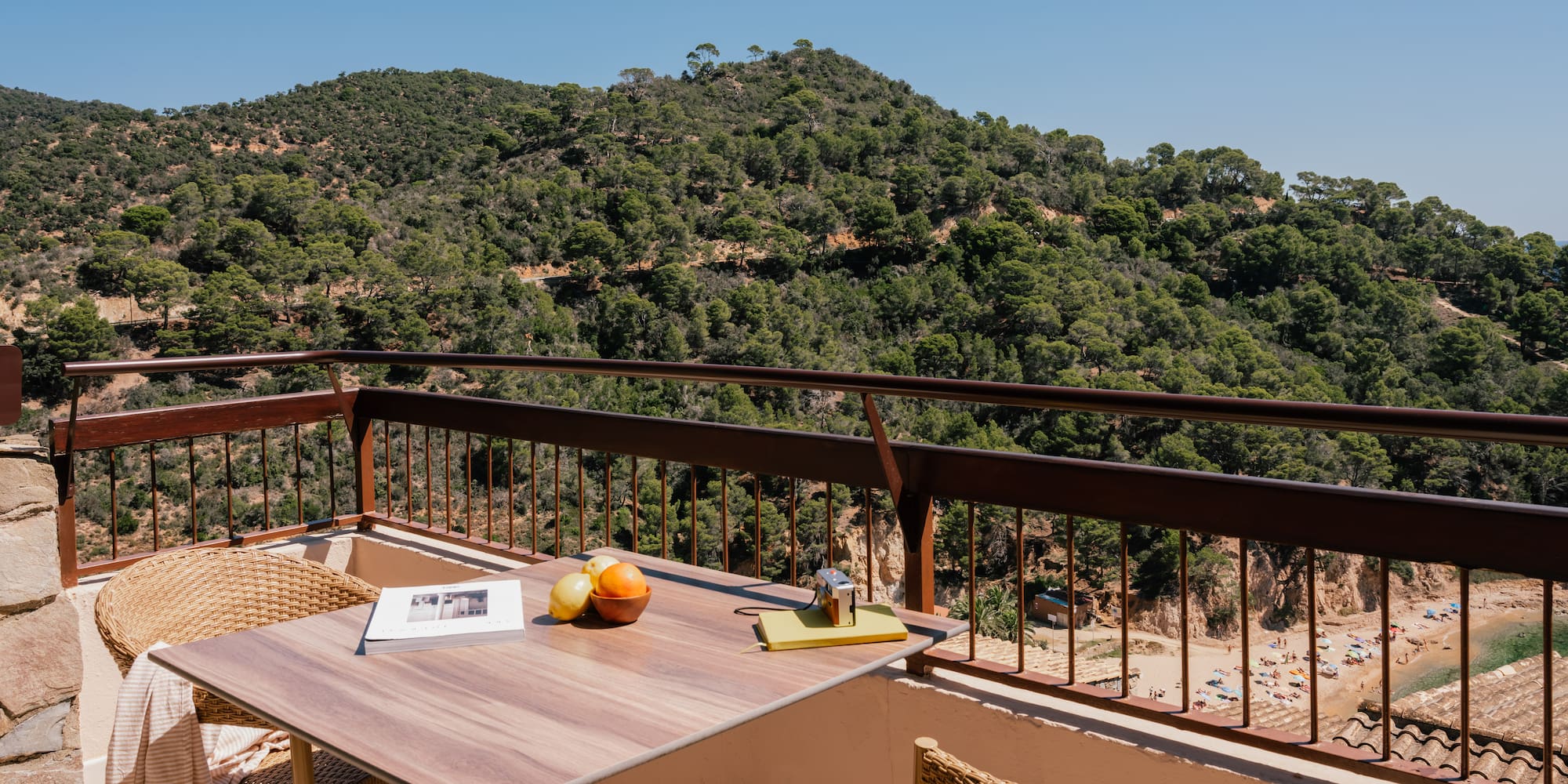 a table and chairs on a balcony overlooking a mountain