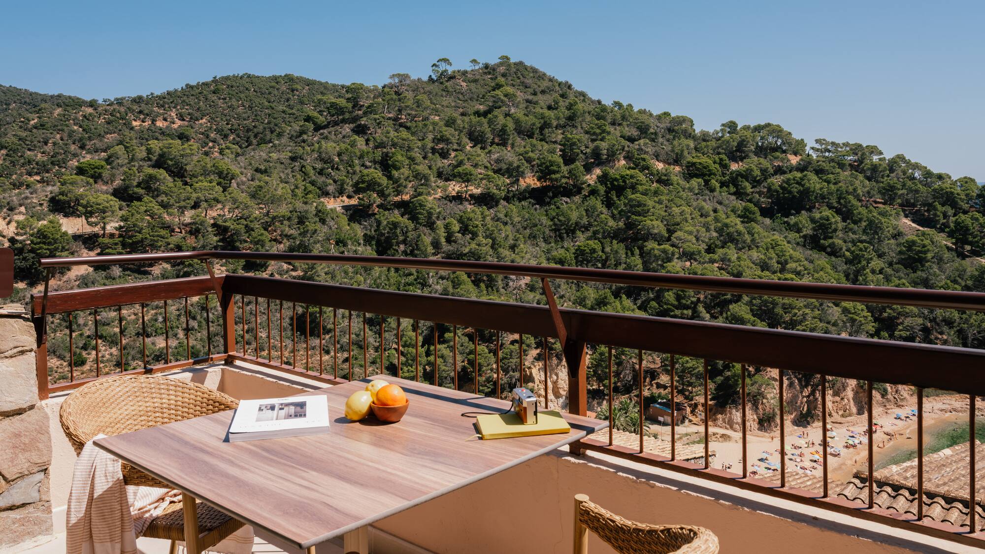 a table and chairs on a balcony overlooking a mountain