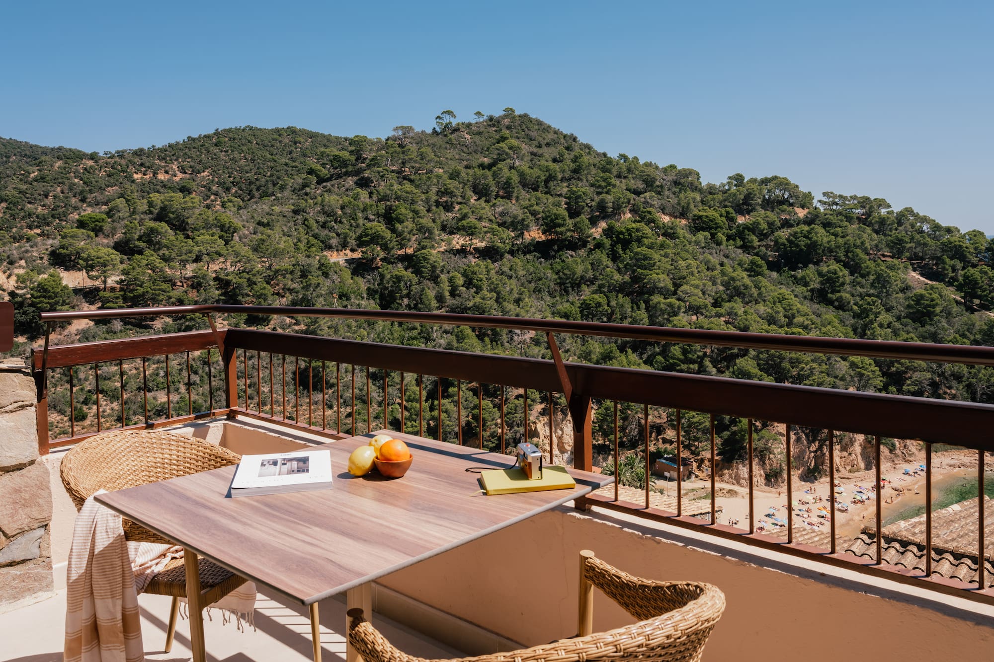 a table and chairs on a balcony overlooking a mountain