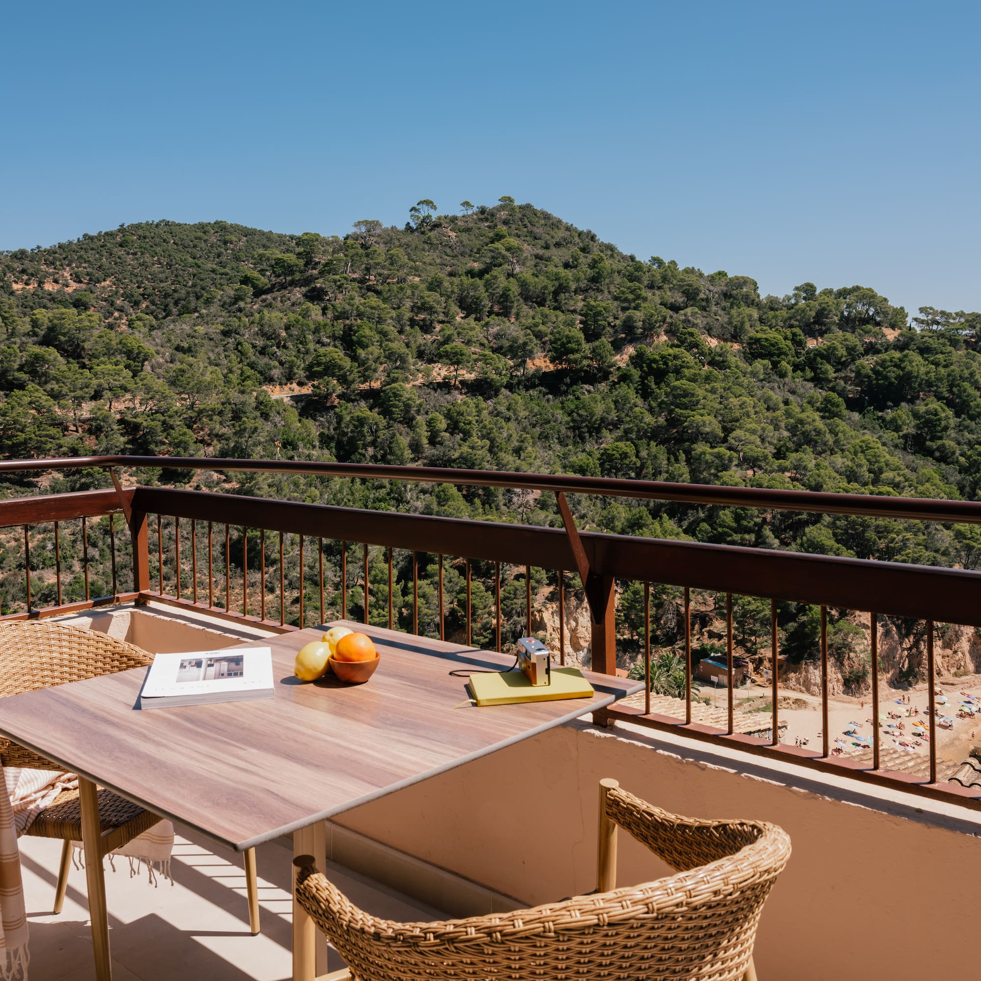 a table and chairs on a balcony overlooking a mountain
