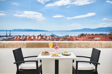 a table with food on it and chairs on a balcony