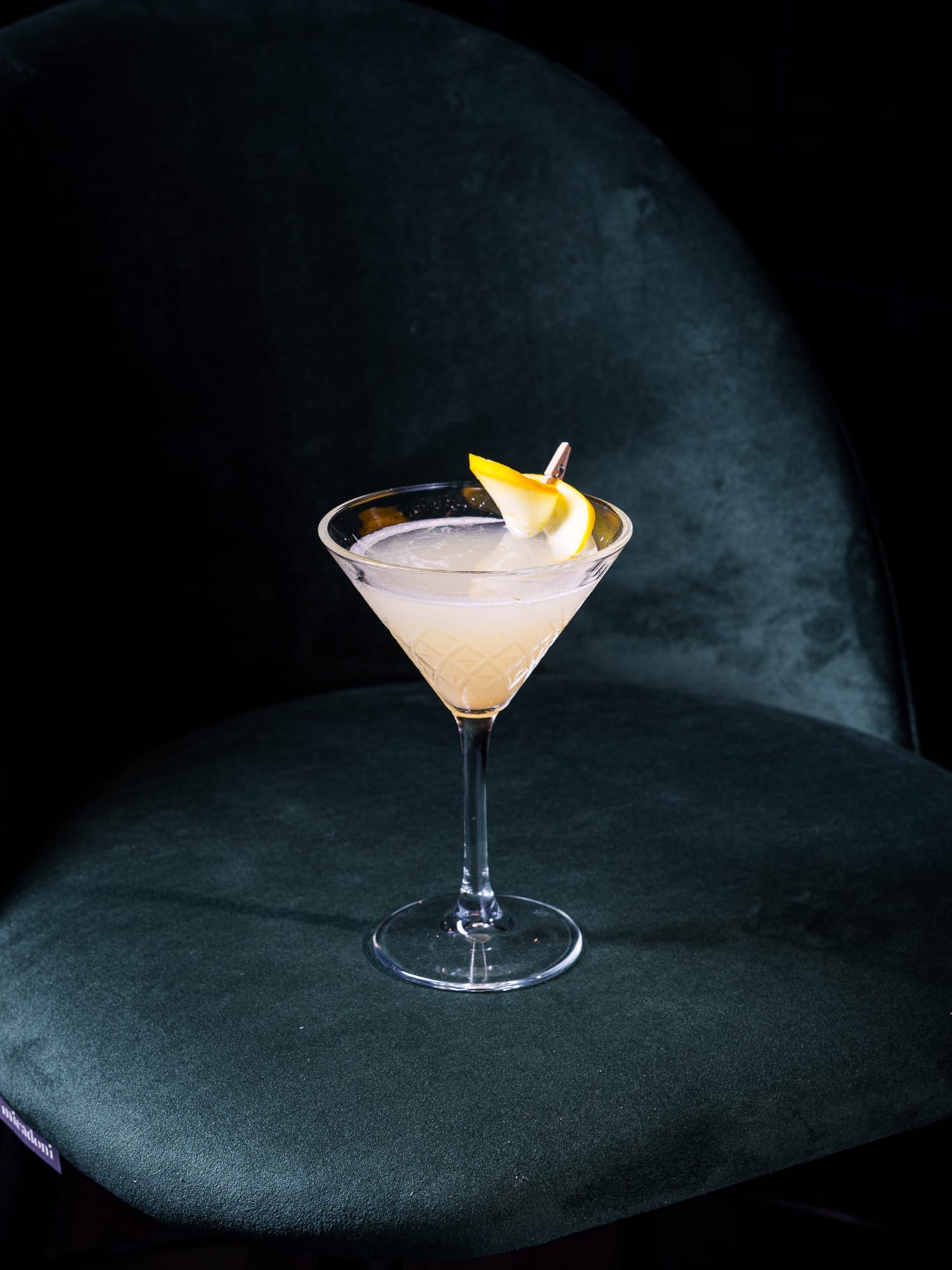 a glass with a drink and a slice of lemon on it