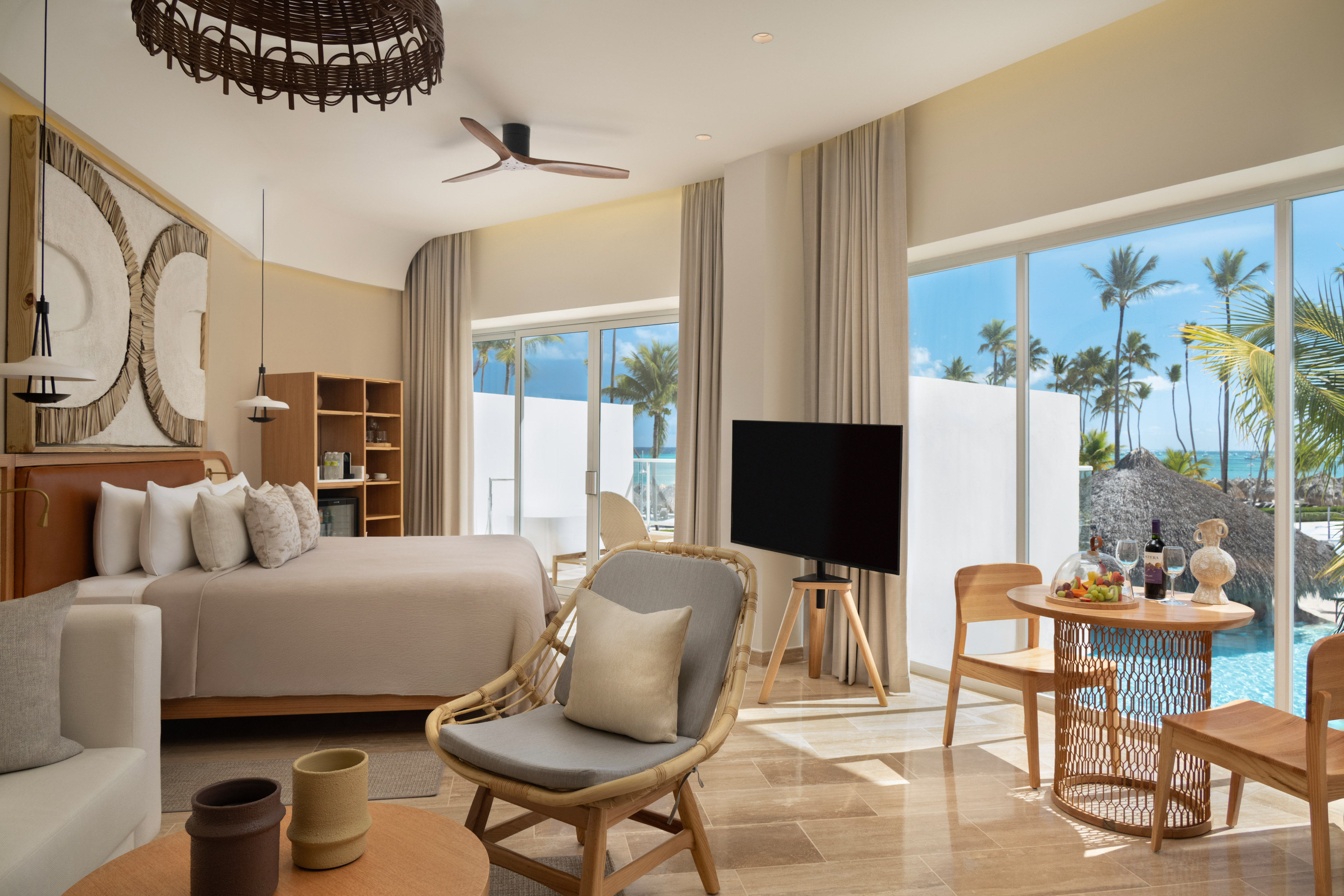 Modern tropical hotel suite with ocean view, king bed, and contemporary furnishings.