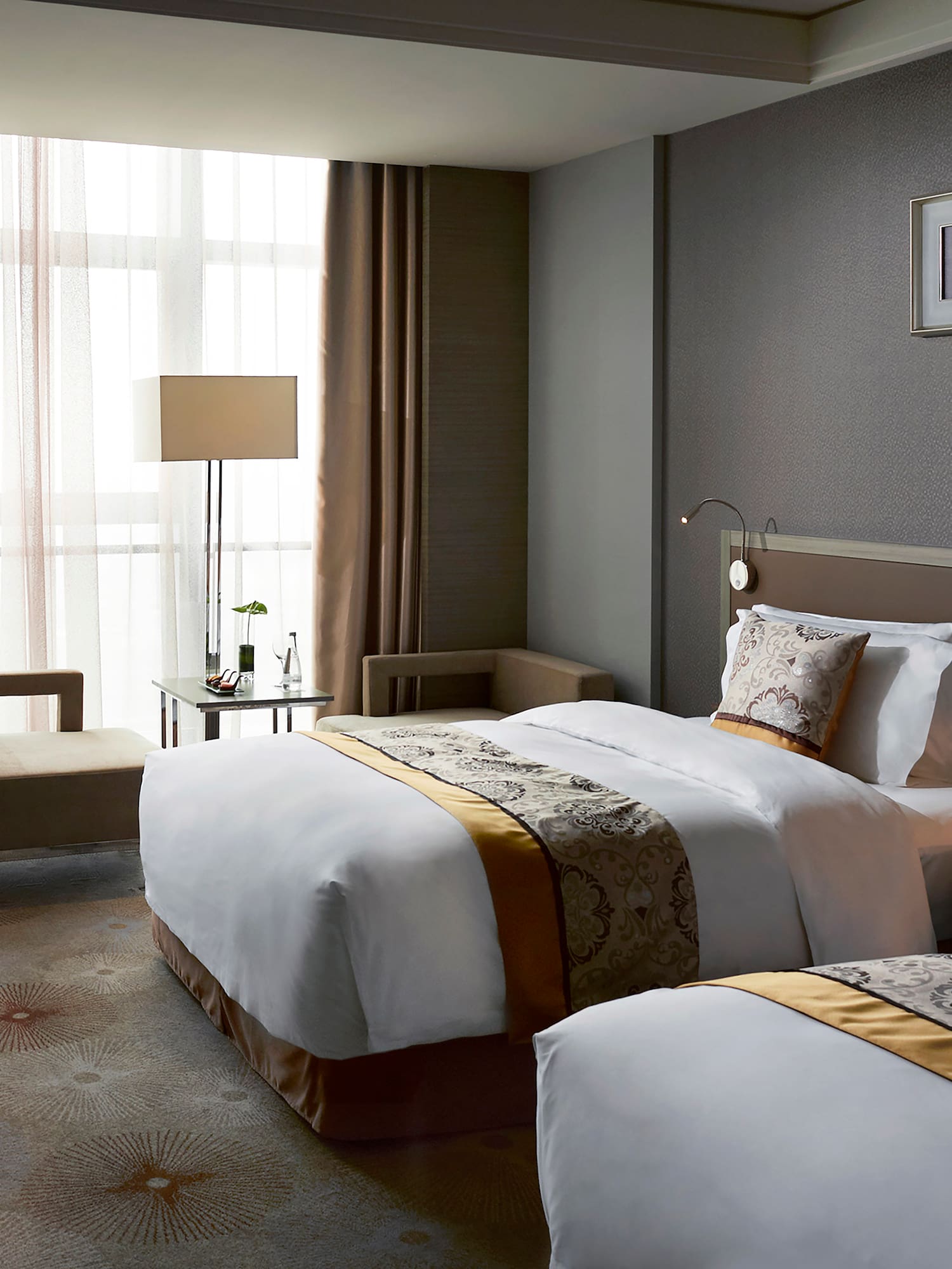 a room with two beds and a lamp