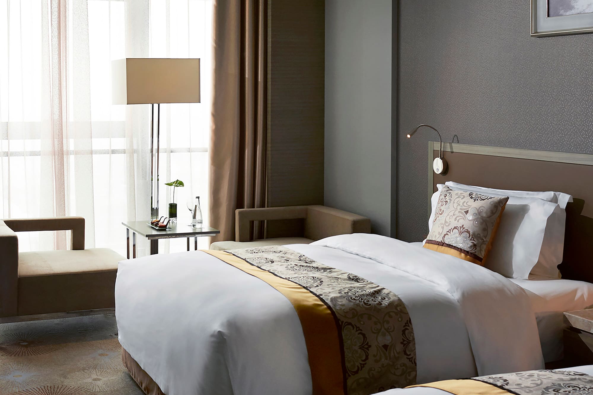 a room with two beds and a lamp