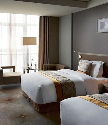 a room with two beds and a lamp