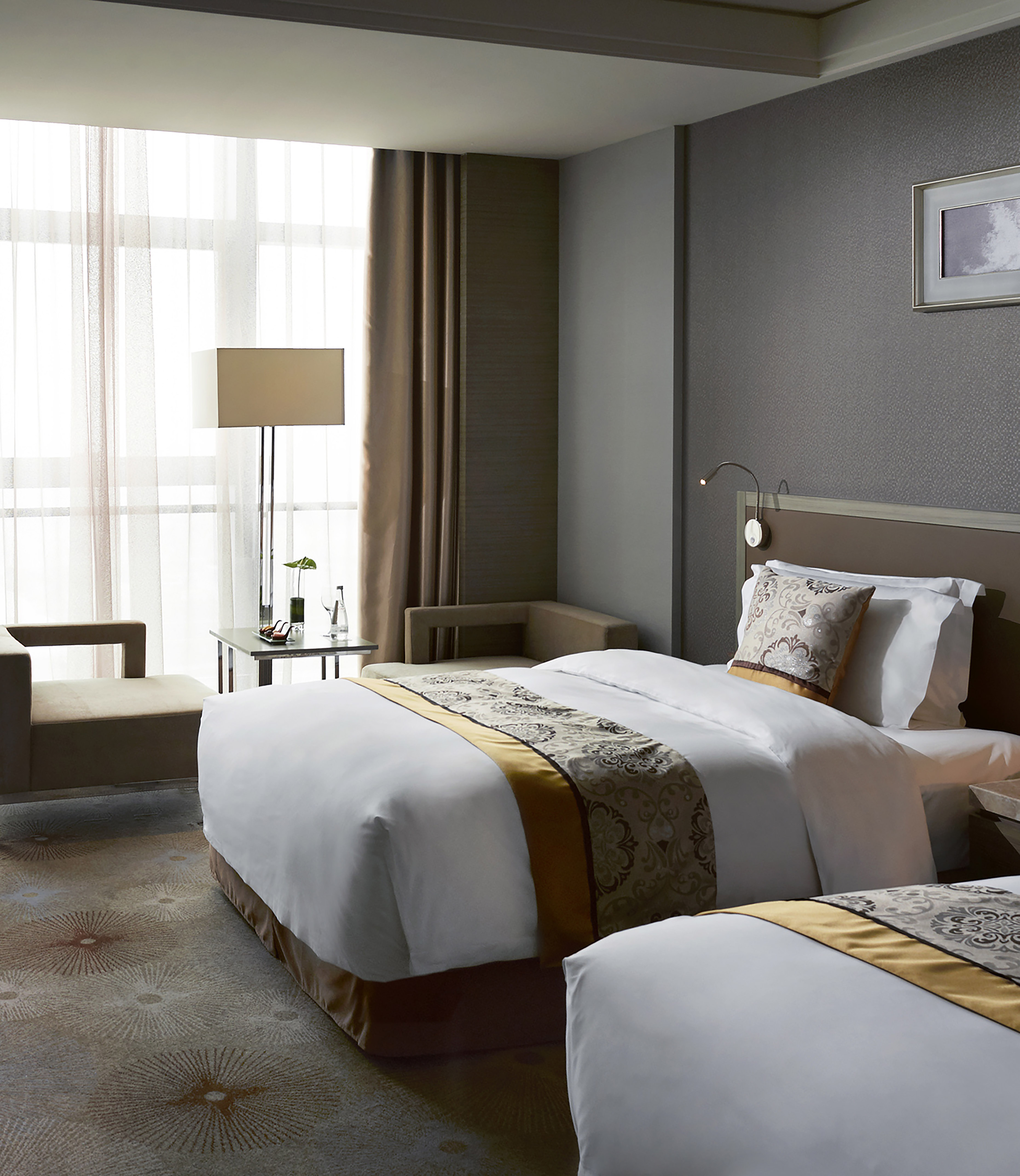 Luxury hotel room with two beds, elegant decor, and large window.