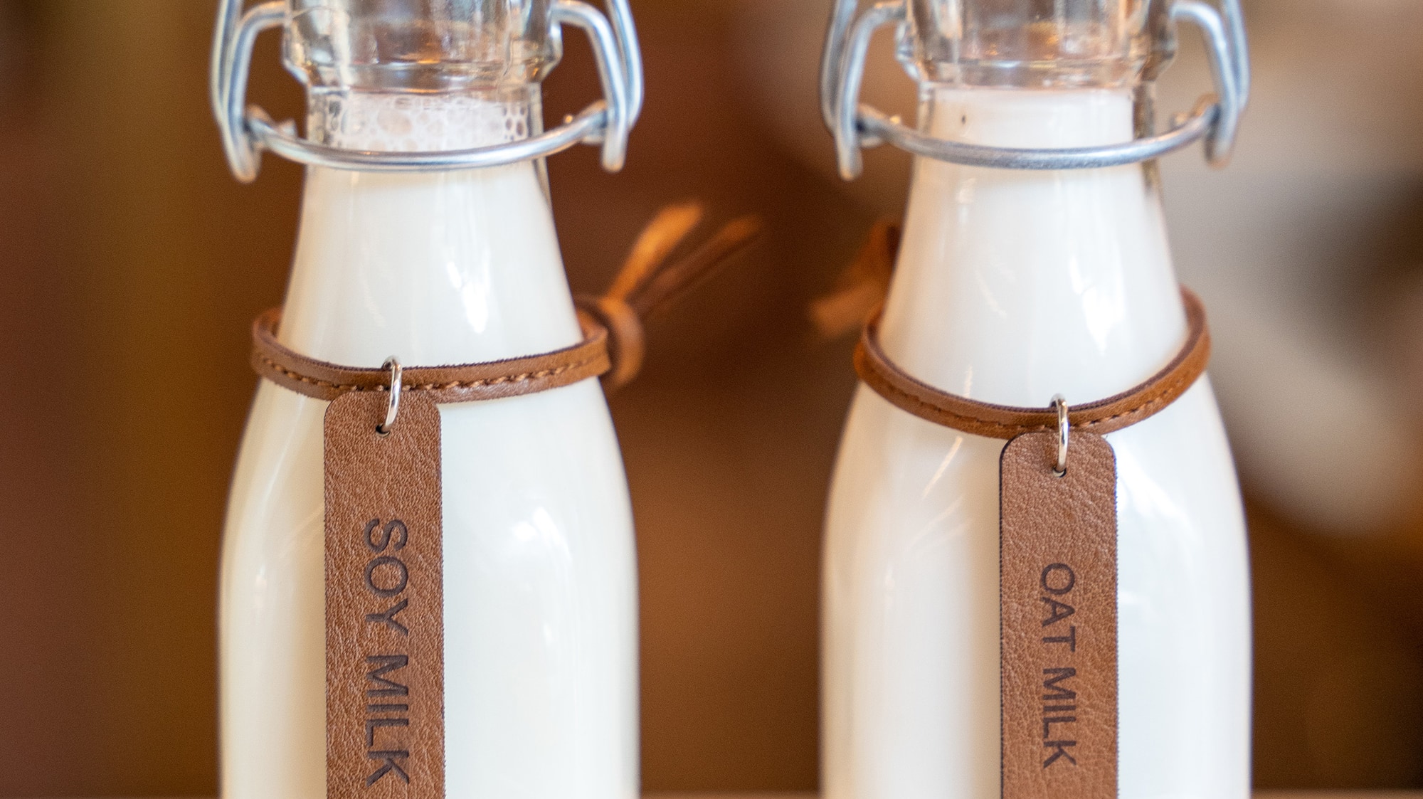 two bottles of milk with a leather strap
