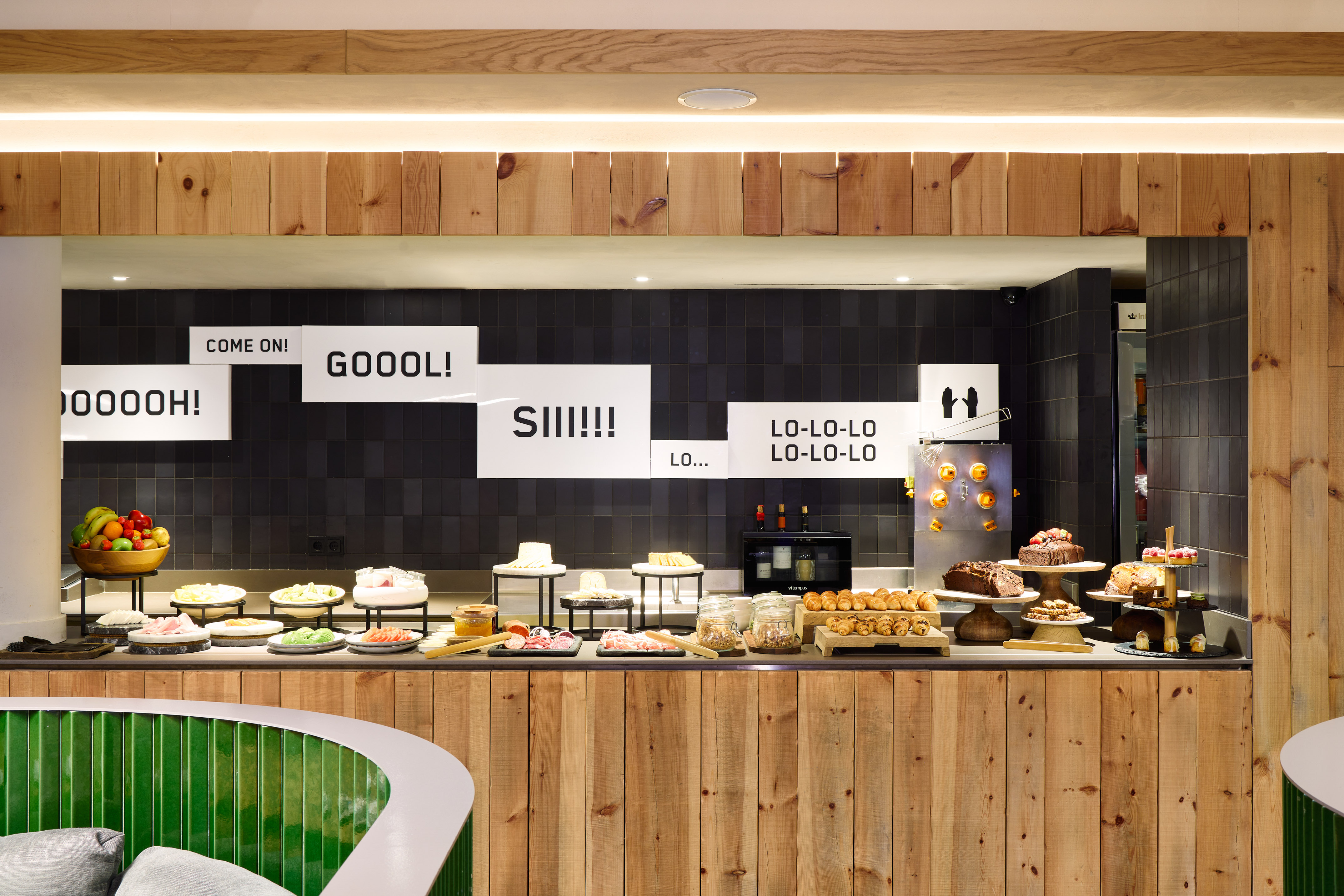 Modern hotel breakfast buffet with diverse food selections and wood accents.
